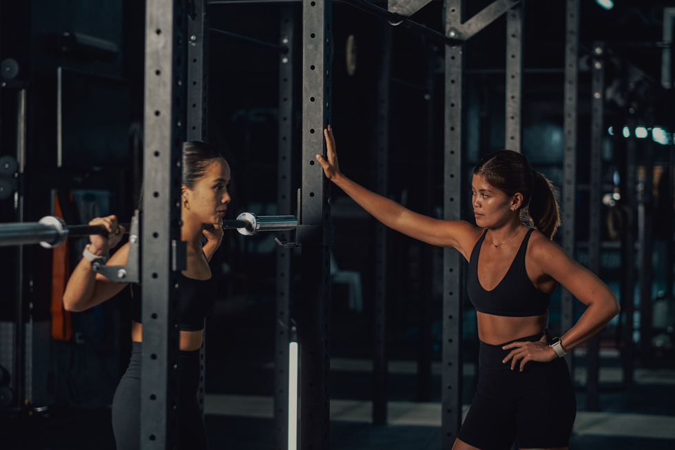 Female Trainers and Woman Lifting Weights in Gym