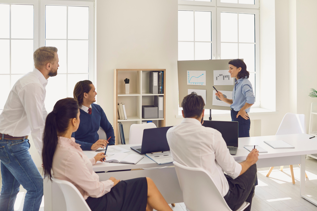Young Woman Demonstrates Some New Project Ideas to Her Partners in a Conference Room.