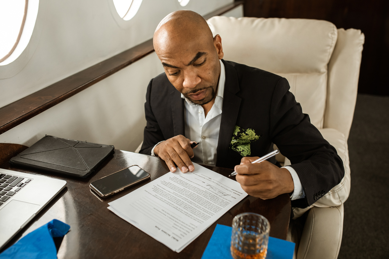 Business Man doing Paperwork while riding a Private Jet 