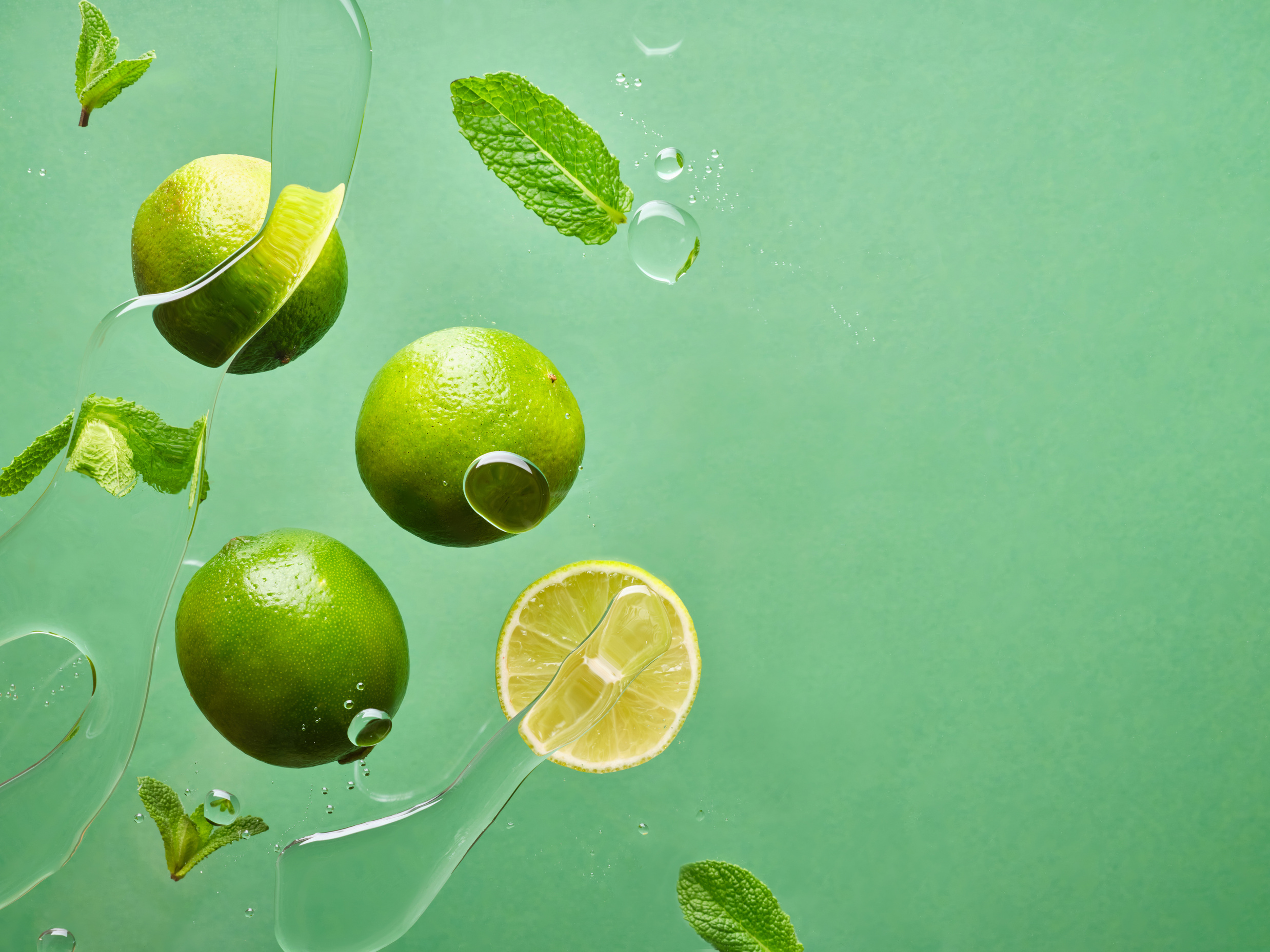 Floating Food Limes and Mint on Green Background
