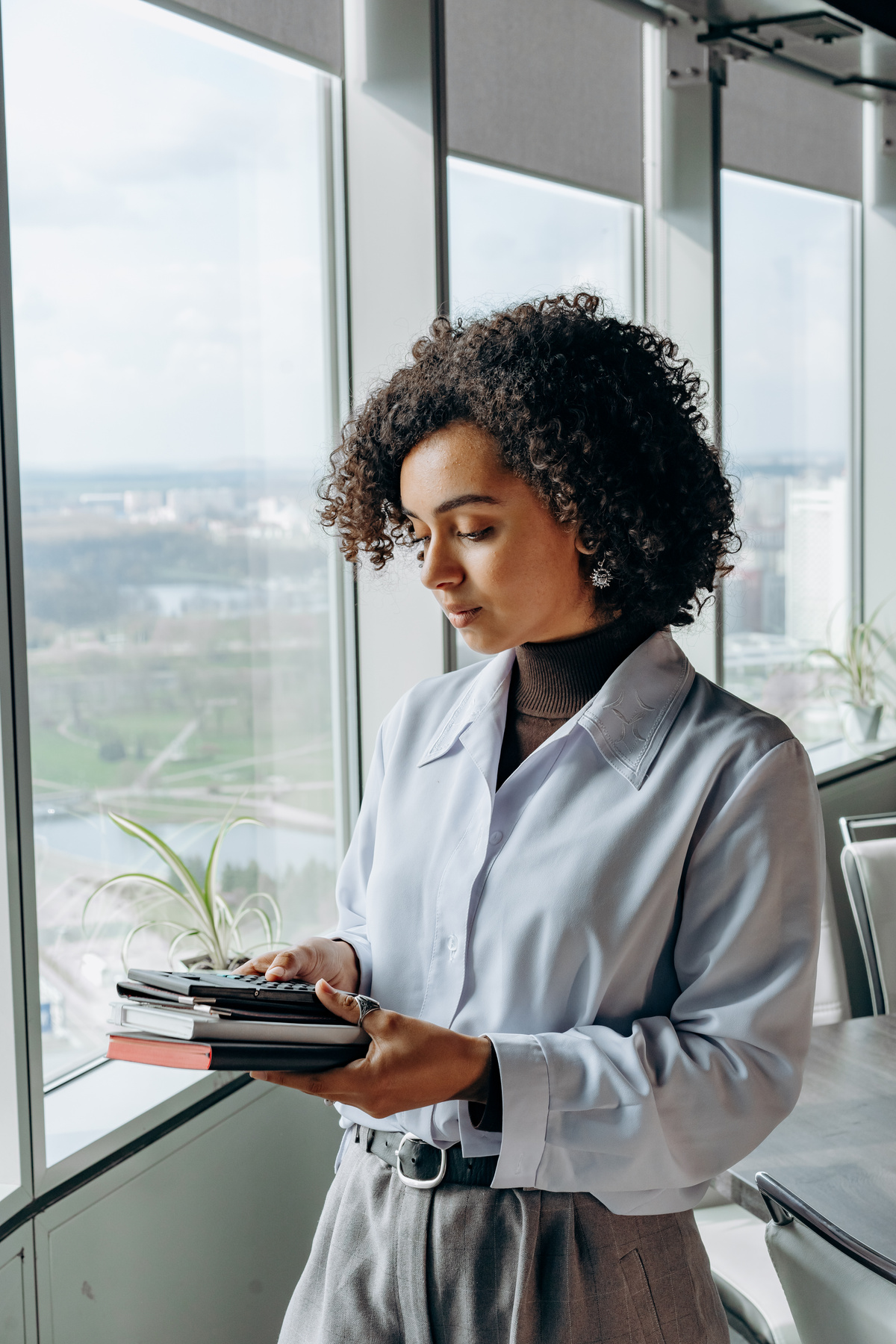 Woman in Gray Long Sleeves Holding Notebooks