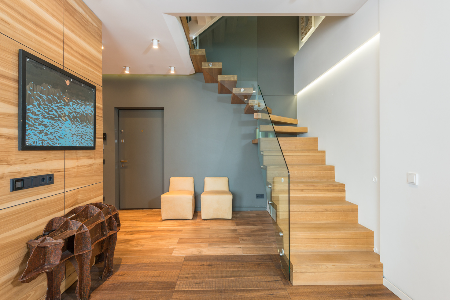 Modern mansion hallway with wooden staircase